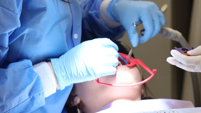 Patient wearing protective glasses being treated in the dental chair