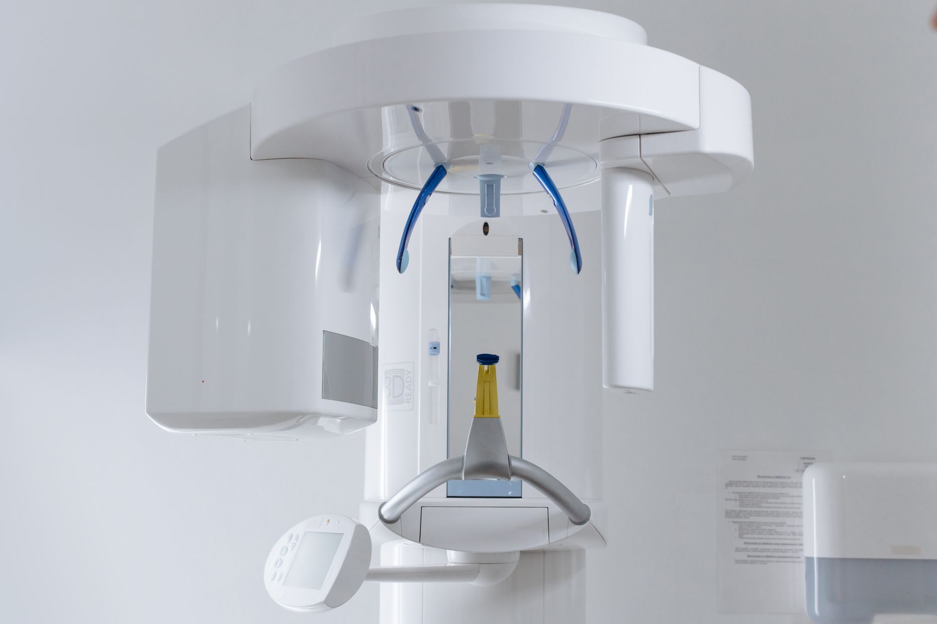 A panoramic dental X-ray unit standing empty in a clinic room